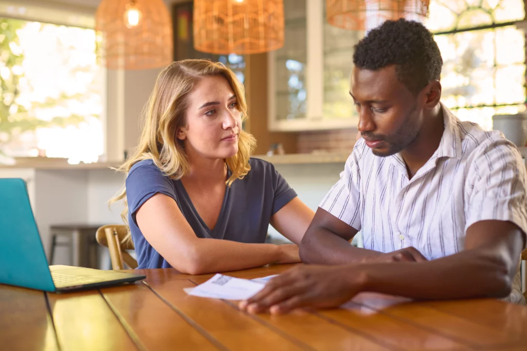 Couple reviewing bills and financial documents at home while considering debt consolidation options in Cartersville.